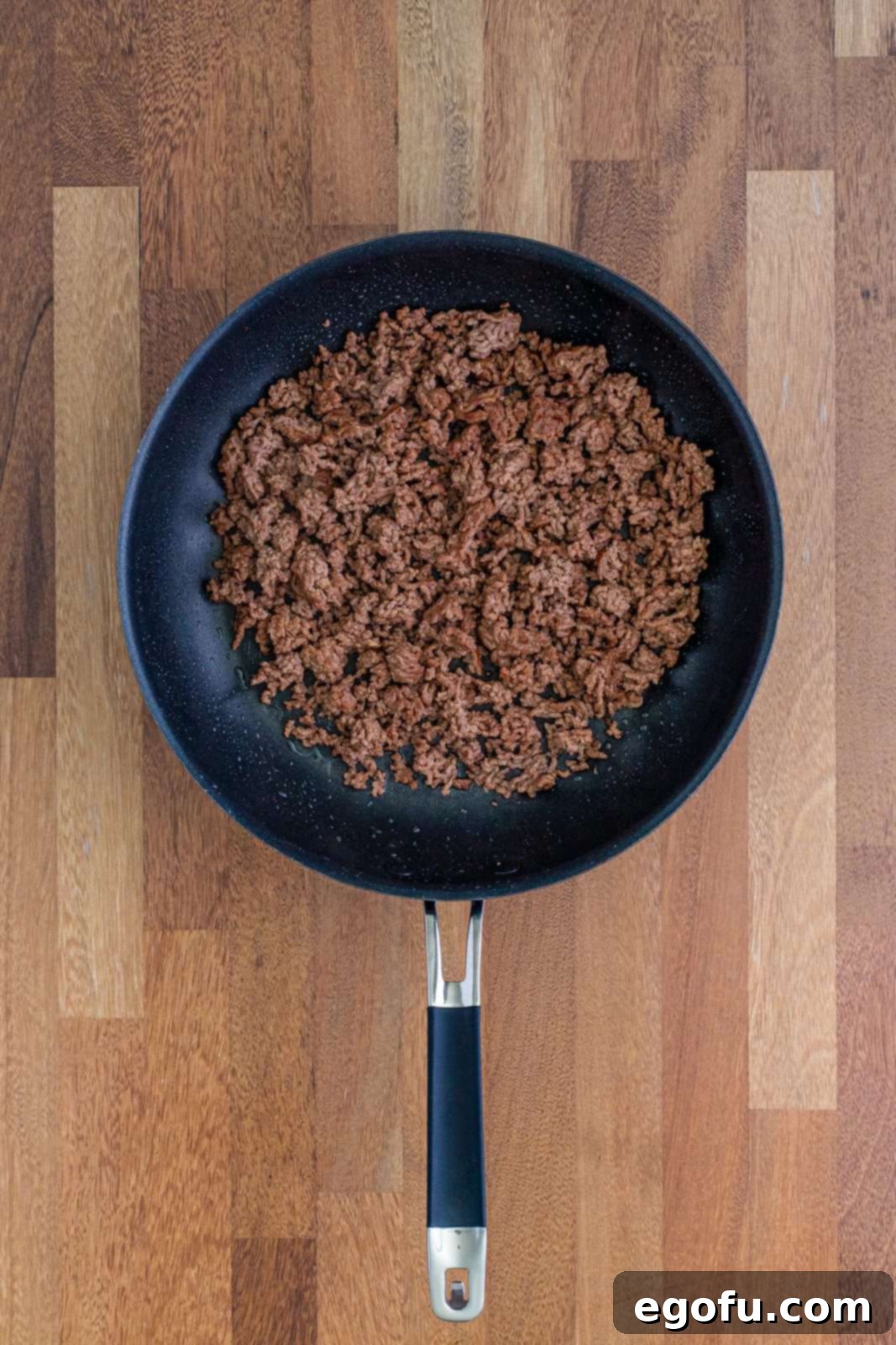 A skillet of cooked ground beef, perfectly browned and ready for seasoning.