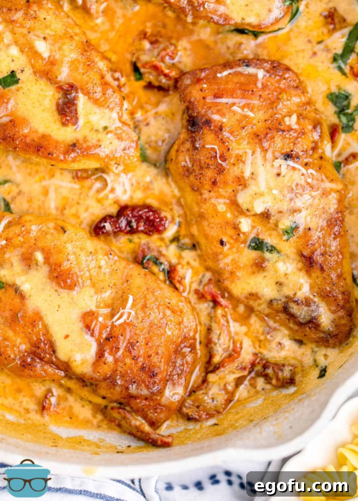 Proposal Chicken 8 Close up, overhead view of Marry Me Chicken in a serving dish, featuring the creamy sauce, sun-dried tomatoes, and fresh basil garnish.