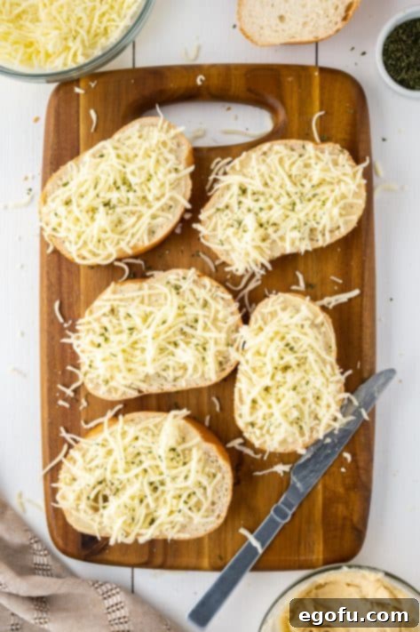 Five pieces of bread with garlic butter and mozzarella cheese sprinkled on top.