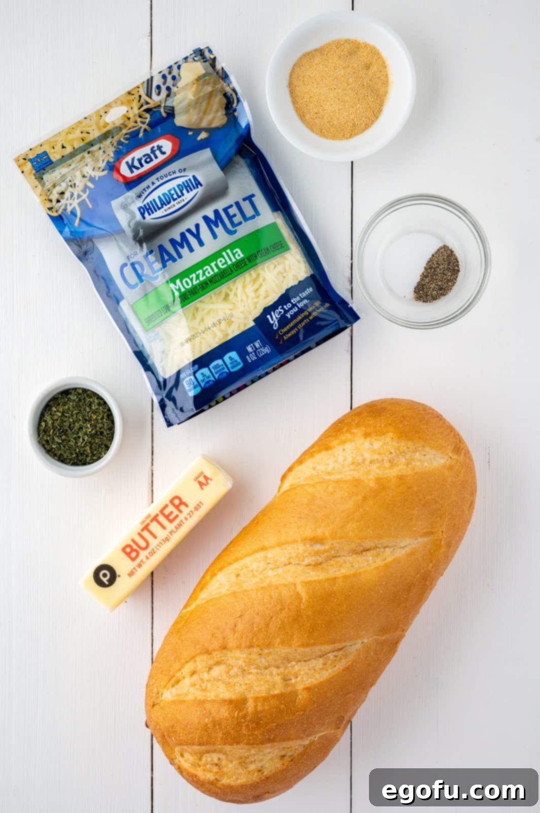 Mozzarella cheese, loaf of bread, garlic powder, salt, pepper, and dried parsley.