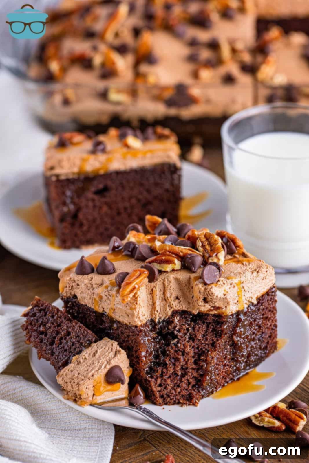 A plate with a piece of cake on it and a fork holding a bite next to it.