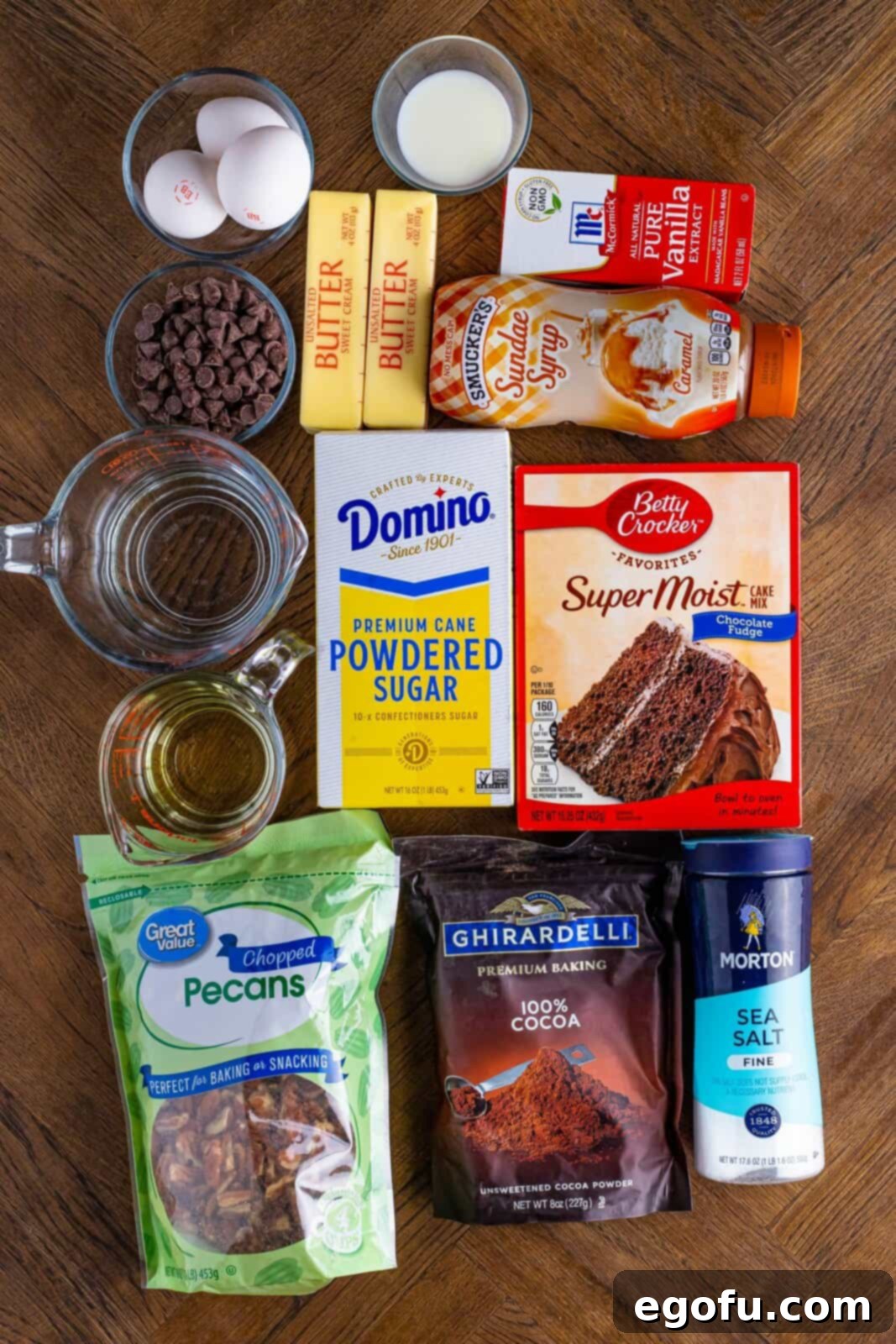 Chocolate Cake mix, eggs, oil, water, caramel topping, powdered sugar, cocoa powder, salted butter, milk, vanilla extract, chopped pecans, and chocolate chips.