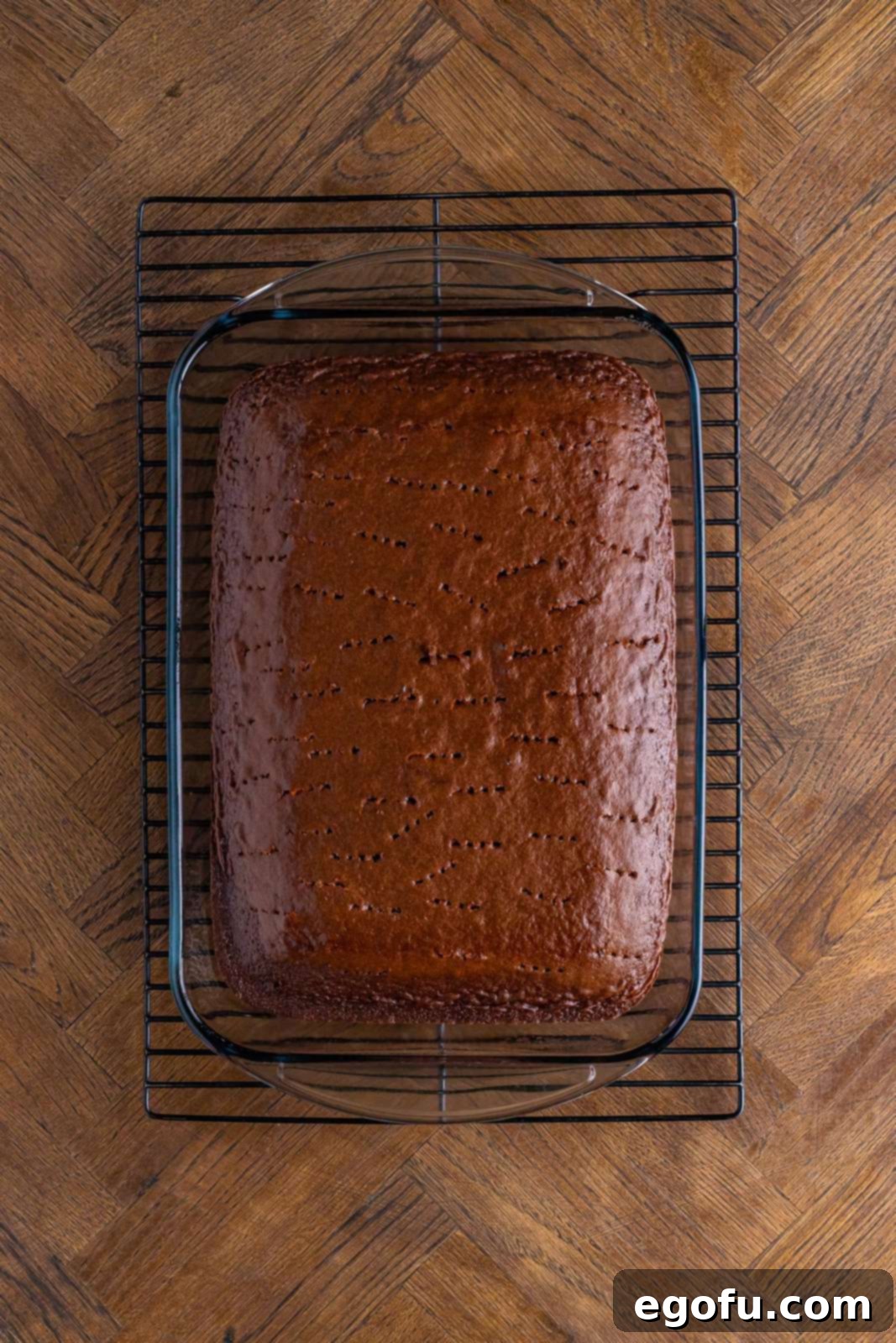 A chocolate cake with holes poked on top. 