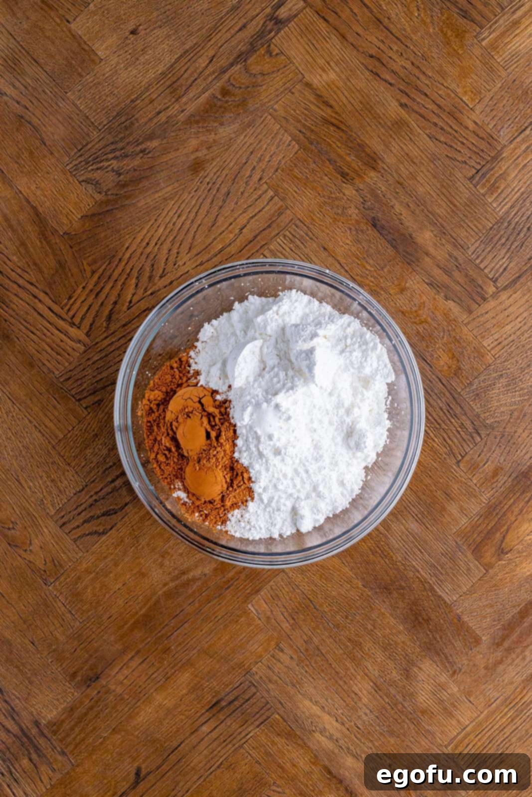Glass bowl with cocoa powder and powdered sugar.