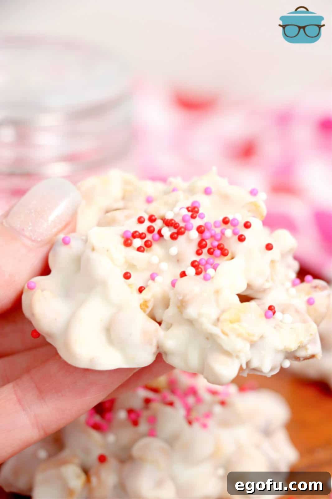 Effortless Slow Cooker Candies 2 A hand holding a piece of candy made in the crockpot with sprinkles.