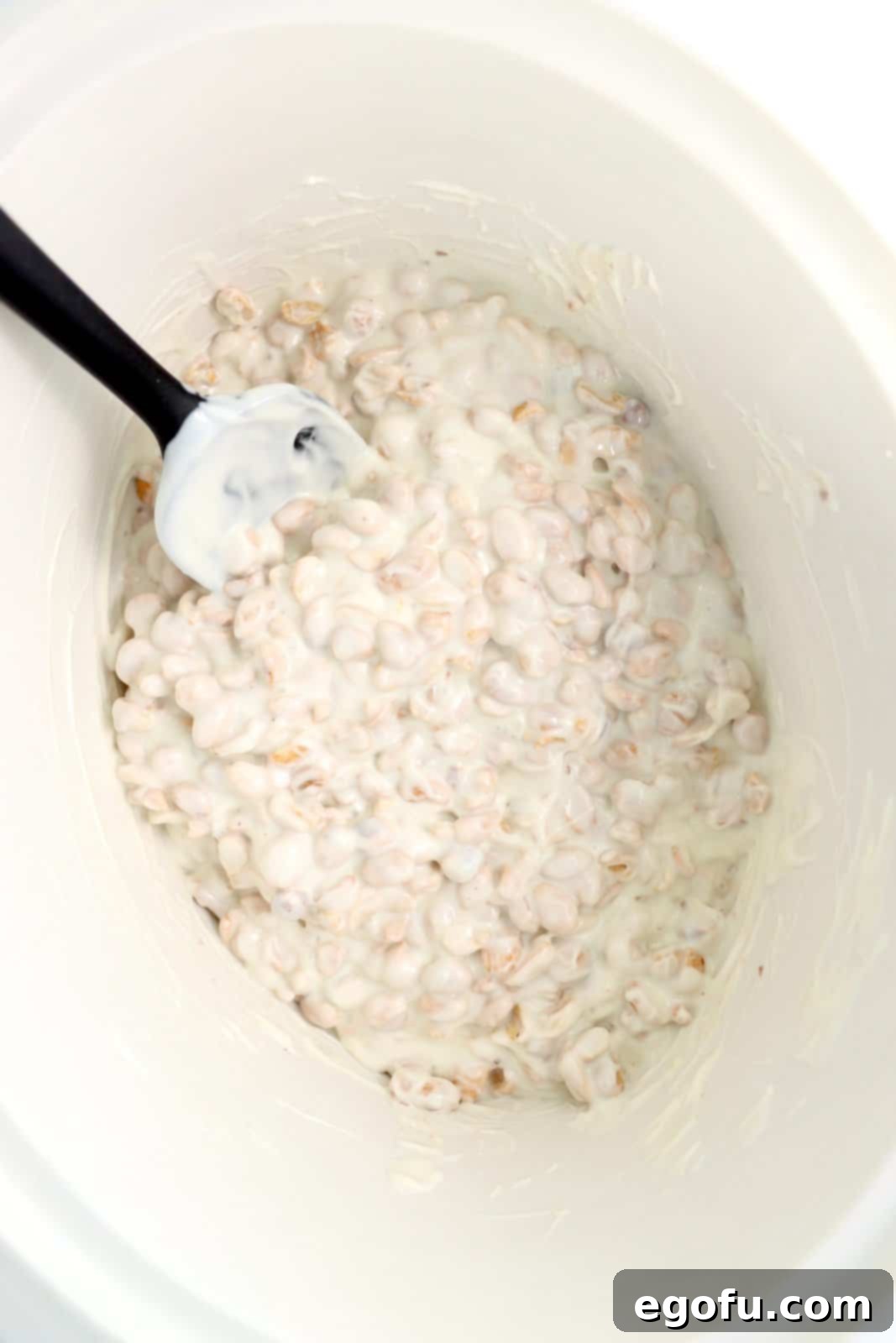 Effortless Slow Cooker Candies 6 Looking down in a crockpot full of melted almond bark and peanuts.