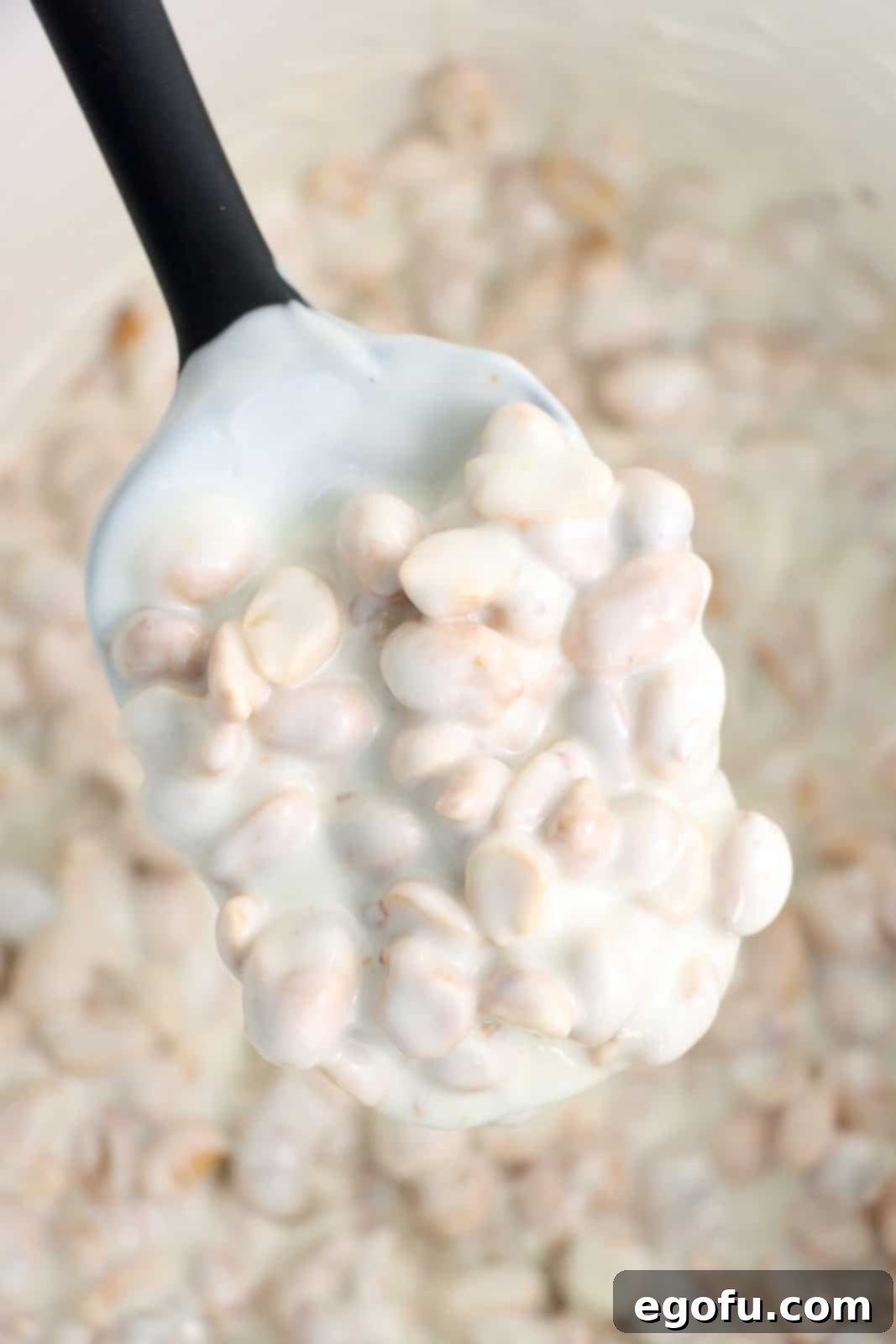 Effortless Slow Cooker Candies 7 A rubber spatula spoon holding some crockpot candy.