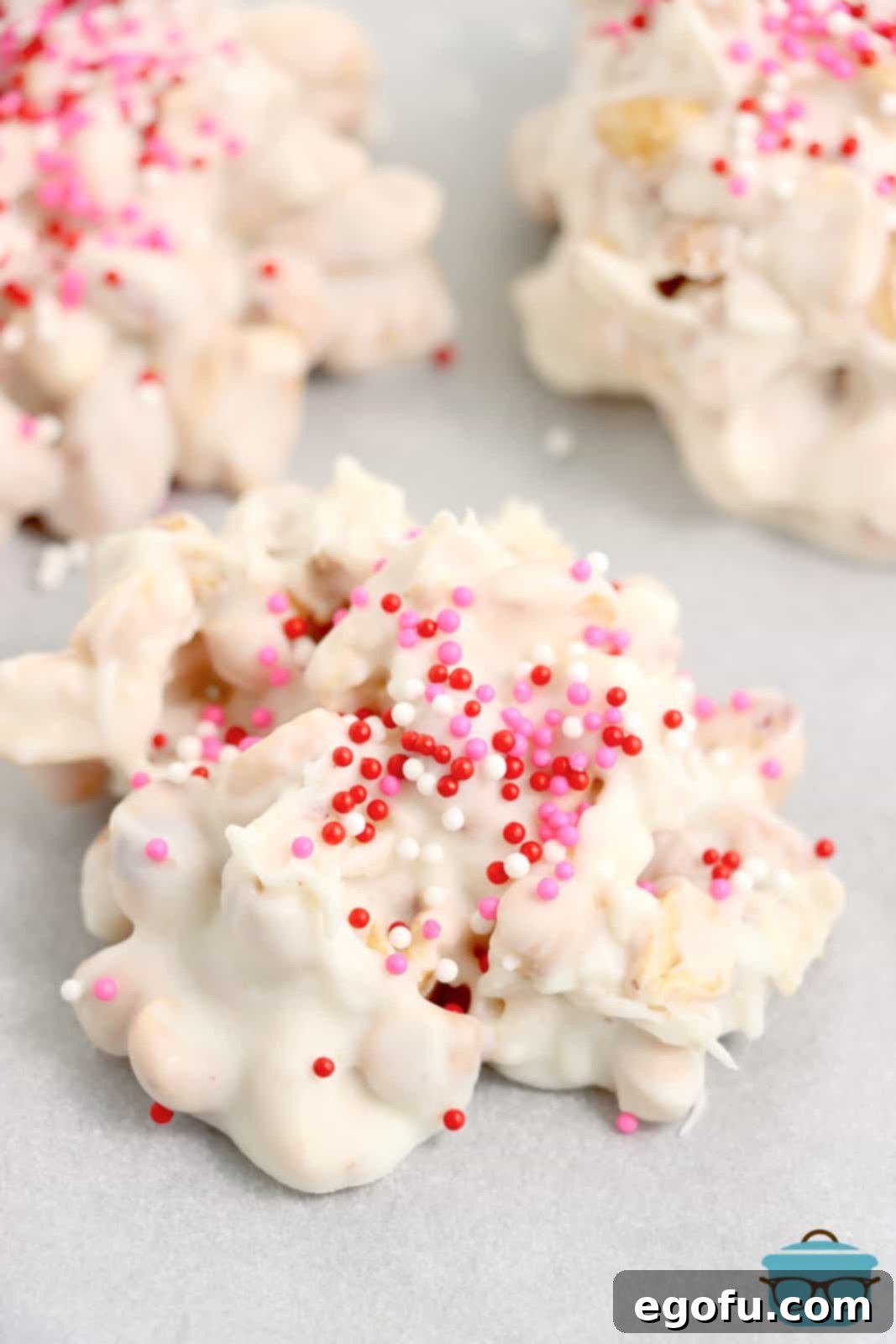 Effortless Slow Cooker Candies 9 A few pieces of Crock Pot Candy with sprinkles on parchment paper.