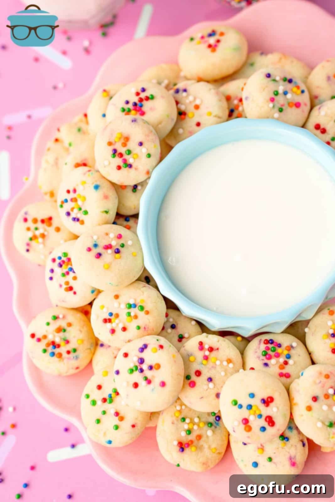 A bowl of frosting surrounded by mini cookies, showcasing their bright colors and inviting texture.