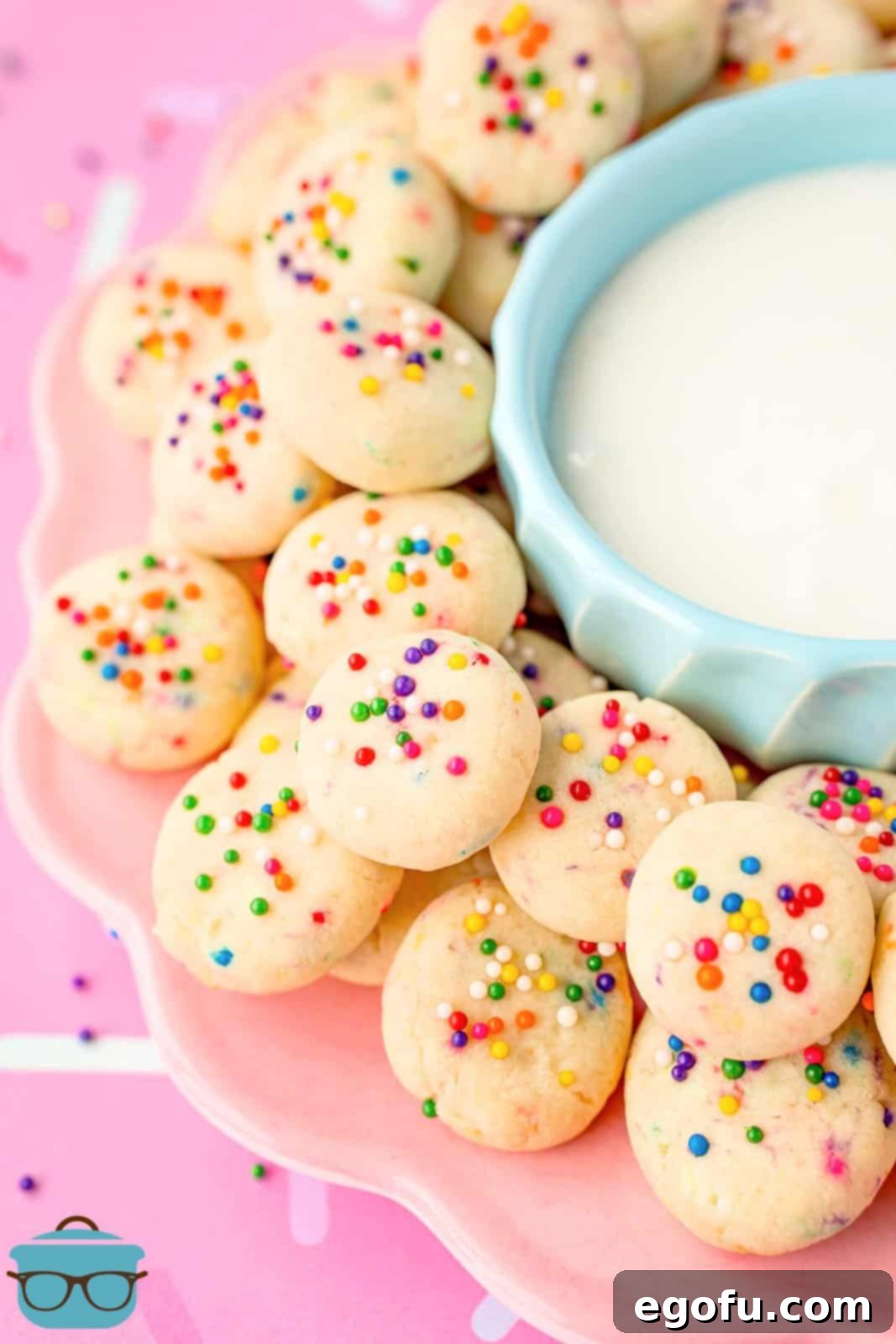 A blue bowl surrounded by small sweetened condensed milk cookie bites, inviting to be eaten.