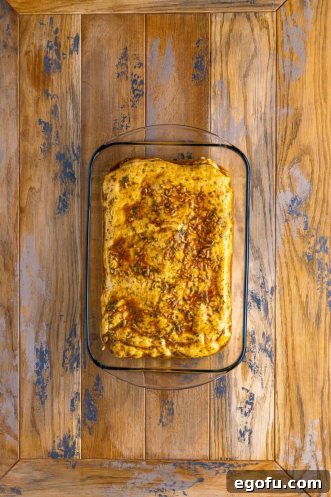A baking dish with the layered French Dip Squares, now brushed with the savory herb and egg wash, ready for baking.