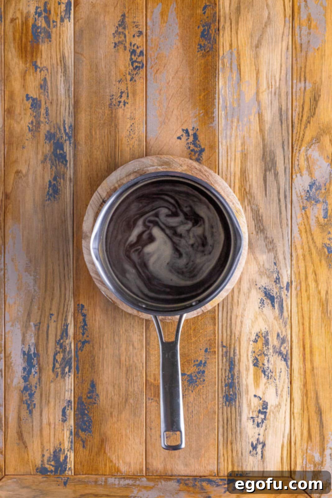 A pot on the stovetop, gently simmering with a rich, dark au jus gravy, ready to accompany the French Dip Squares.