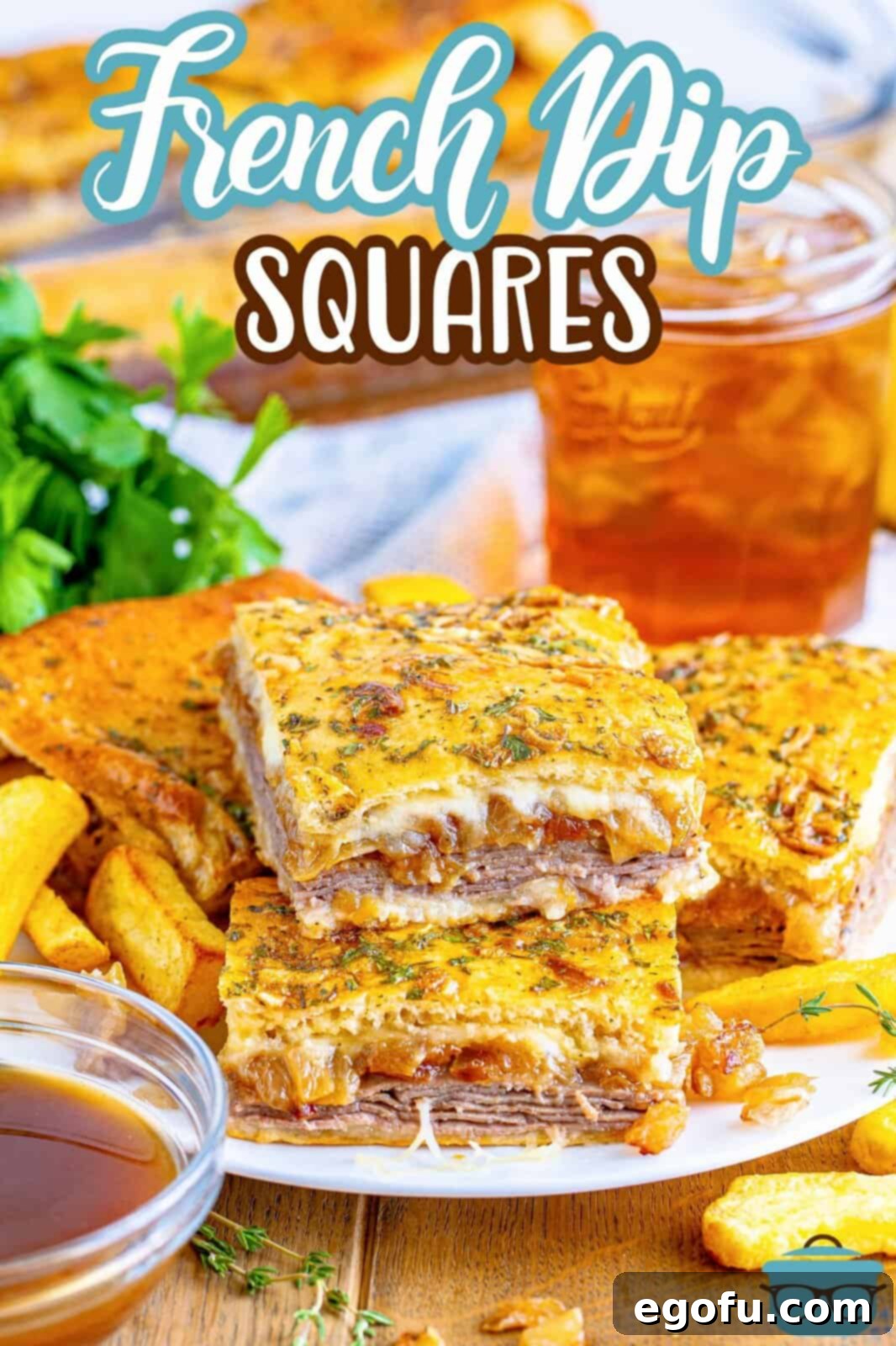 A stack of homemade French Dip Squares on a plate with a drink behind the plate, ready to be served.