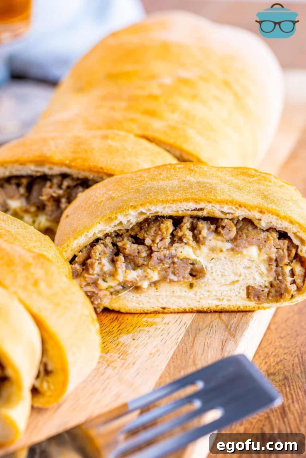 A sliced loaf of Sausage Bread on a cutting board, ready to be served.