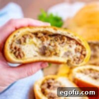 A hand holding a slice of Sausage Bread, inviting you to try this delicious recipe.