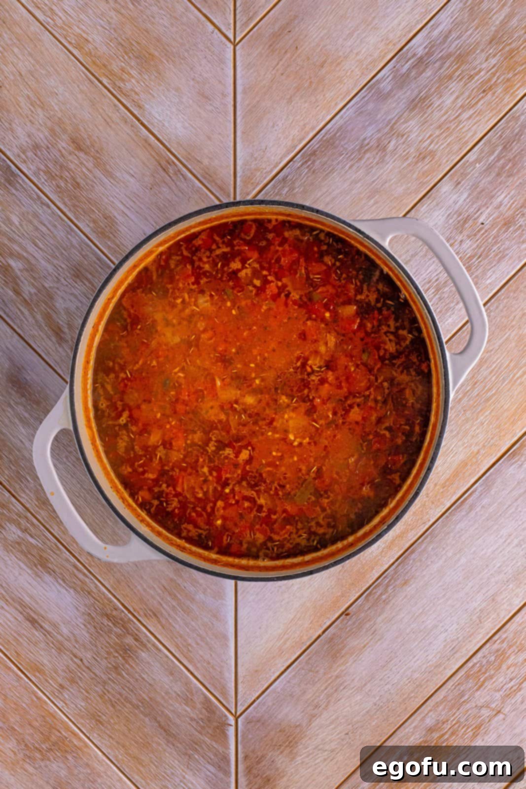 A pot filled with vibrant red tomato-based soup, simmering on the stovetop.