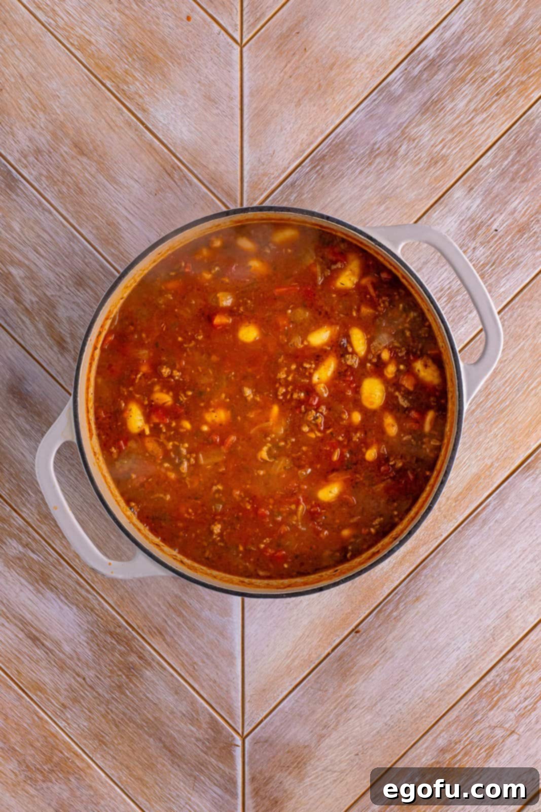 A pot of Italian gnocchi soup with gnocchi just added, beginning to cook.