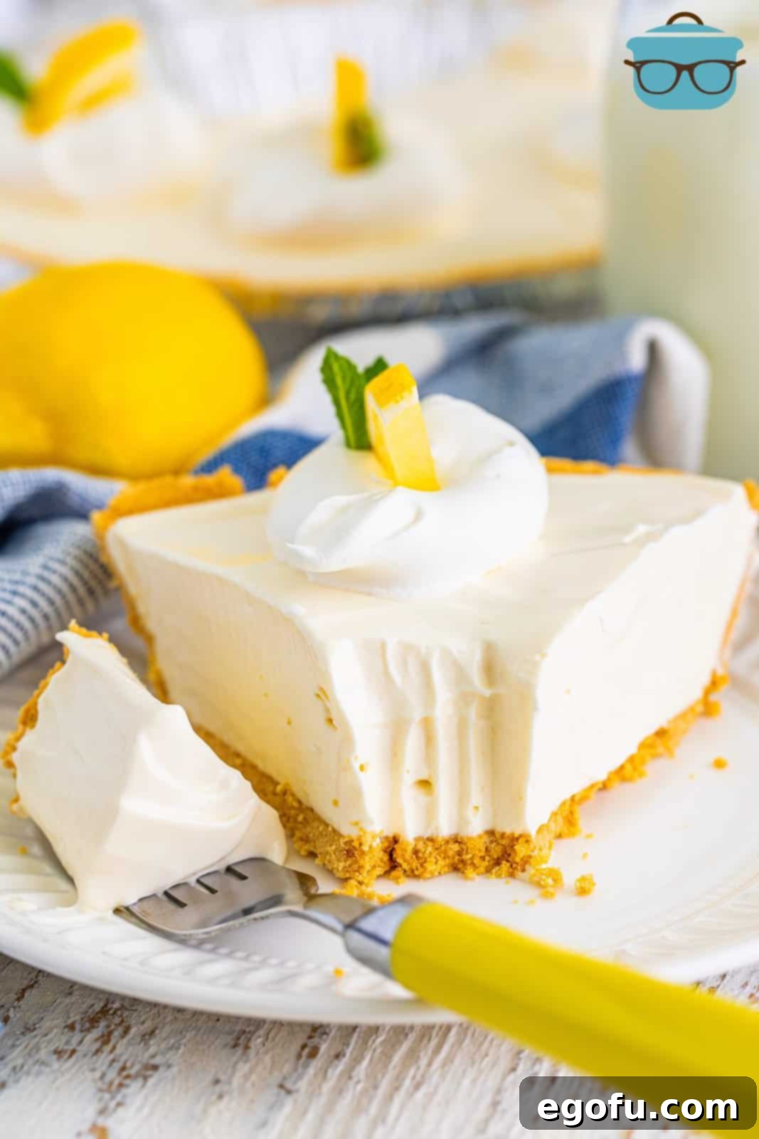 A delicious slice of lemonade pie, with a bite taken, resting on a fork beside it, ready to be enjoyed.
