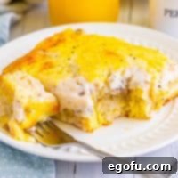 A plate with a serving of biscuits and gravy casserole with a fork.