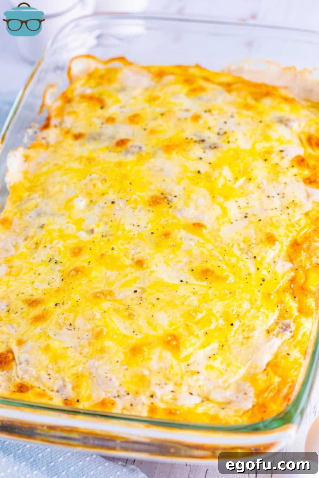 A freshly baked baking dish of Biscuits and Gravy casserole, golden and bubbly.