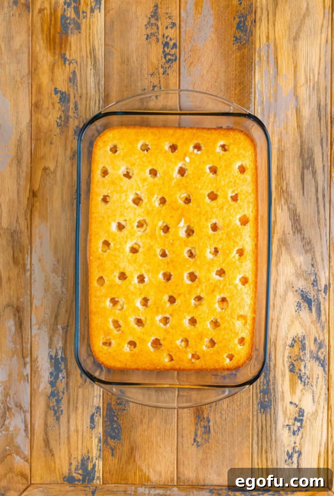 A cake with holes poked in the top.