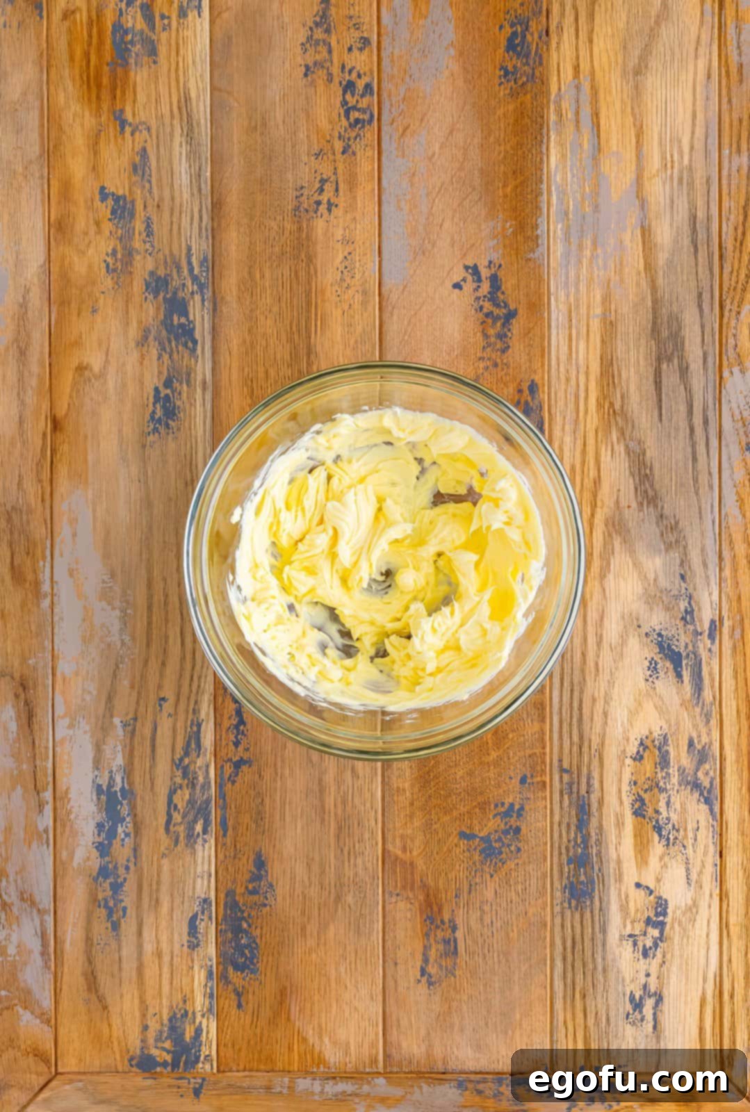 A mixing bowl with beaten butter in it.