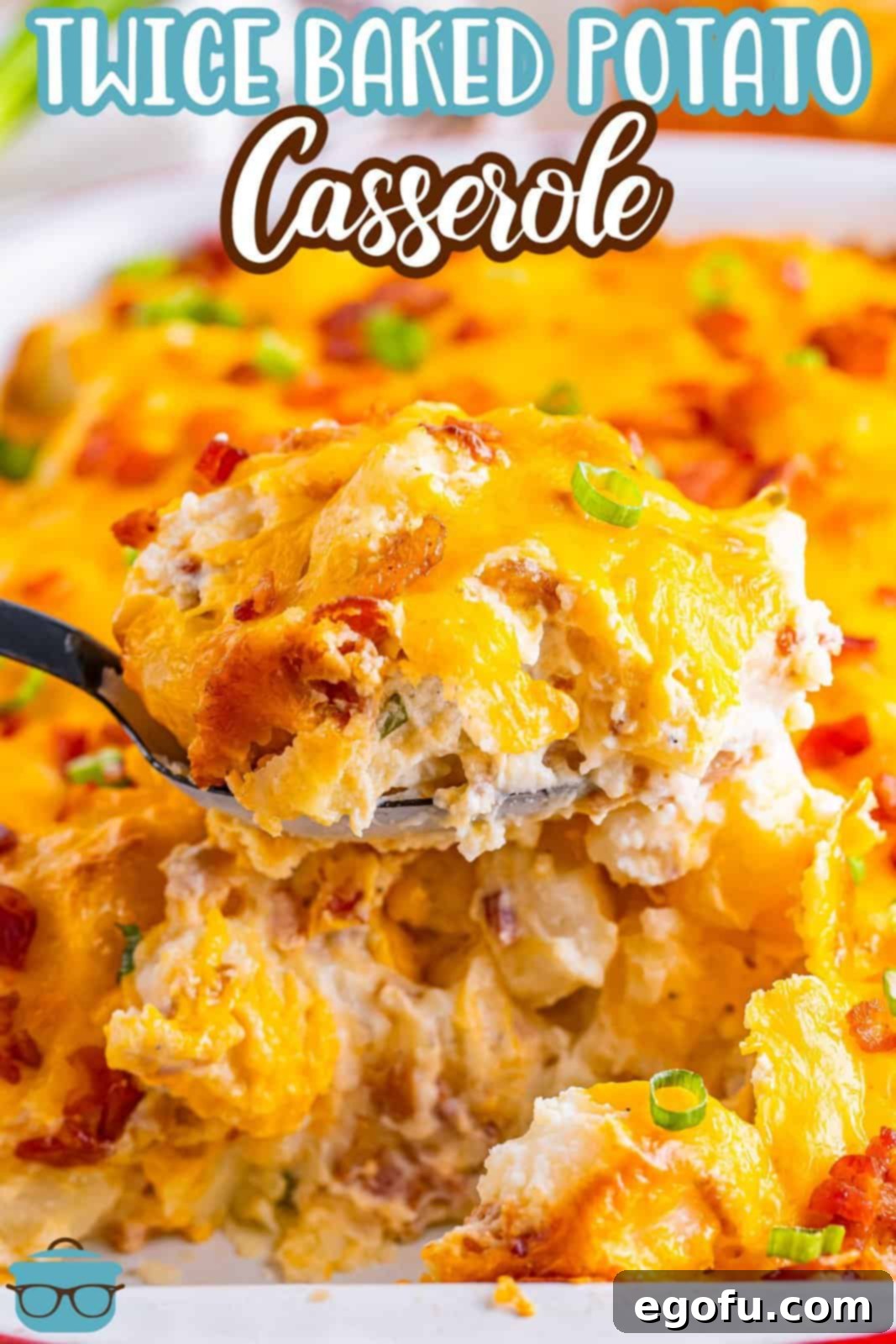 A close-up shot of a perfect bite of Twice Baked Potato Casserole on a fork, positioned in front of a full baking dish of the casserole.