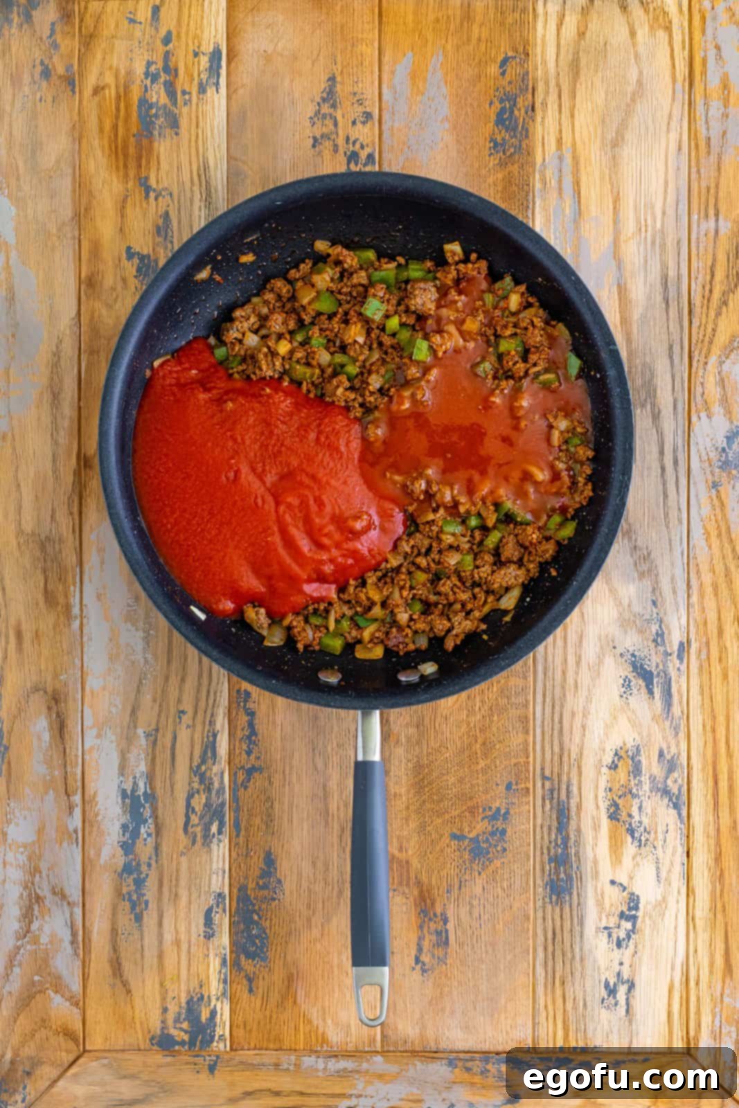 Tomato sauce and enchilada sauce on top of a ground beef mixture. 