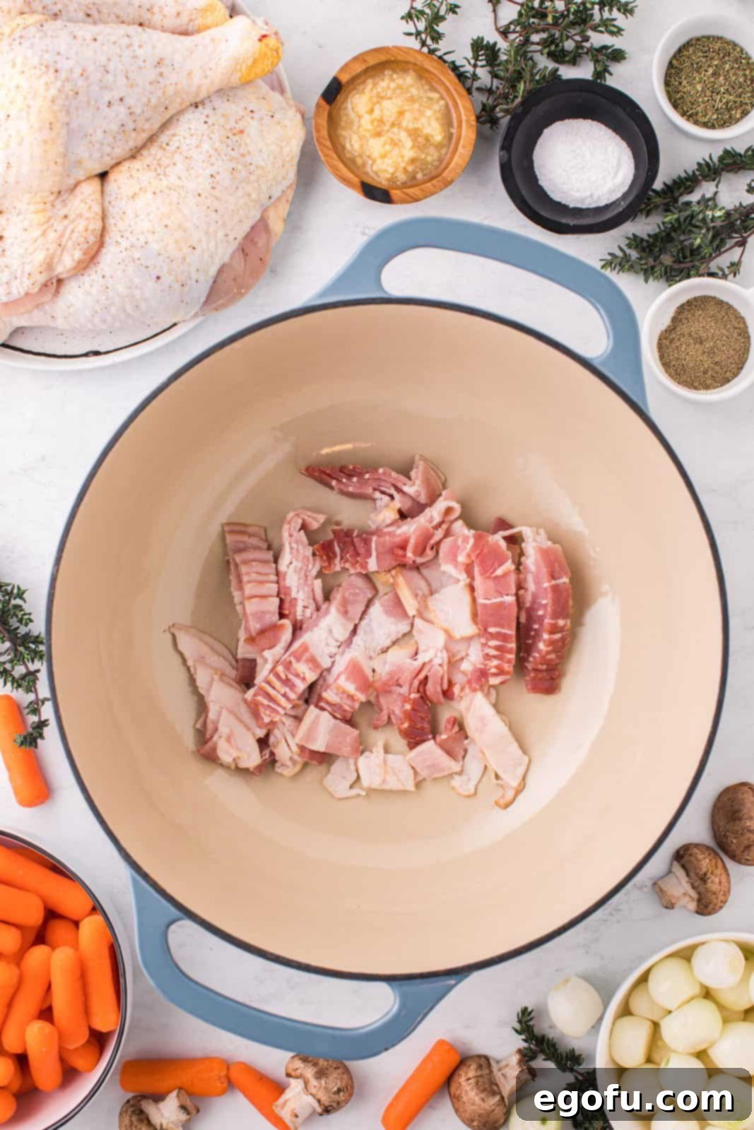 A pot filled with sizzling thick-cut bacon, rendering its fat before the chicken is added.