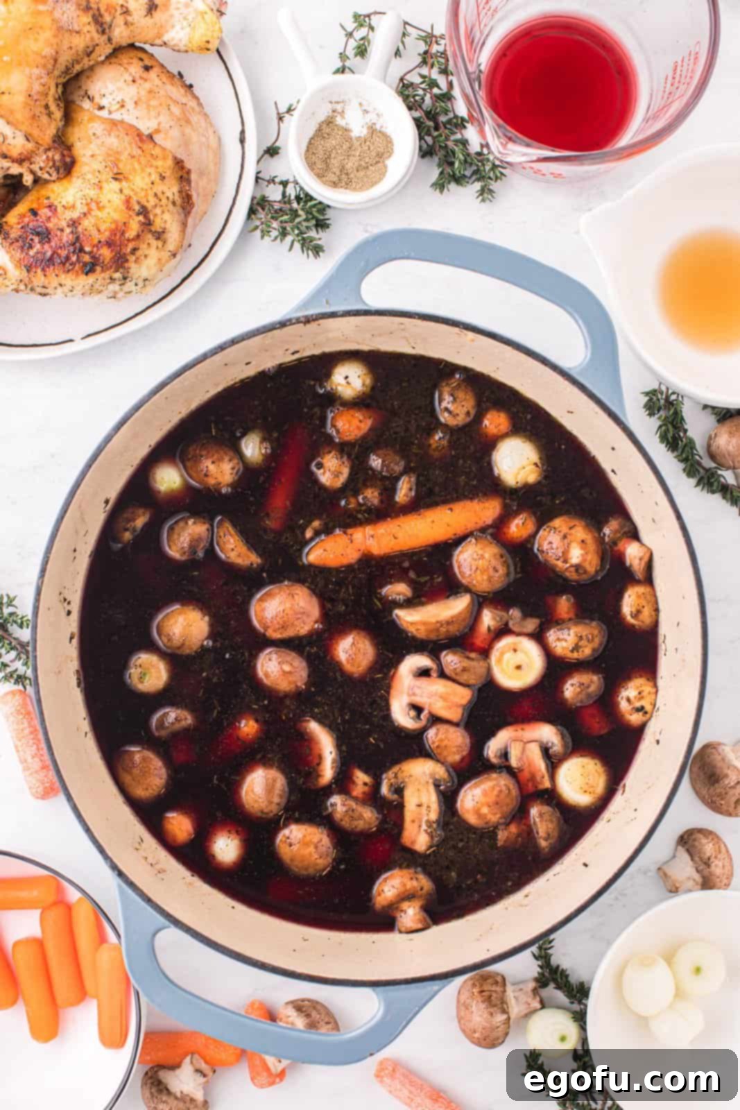 The red wine and chicken stock mixture, with vegetables and aromatics, beginning to simmer.