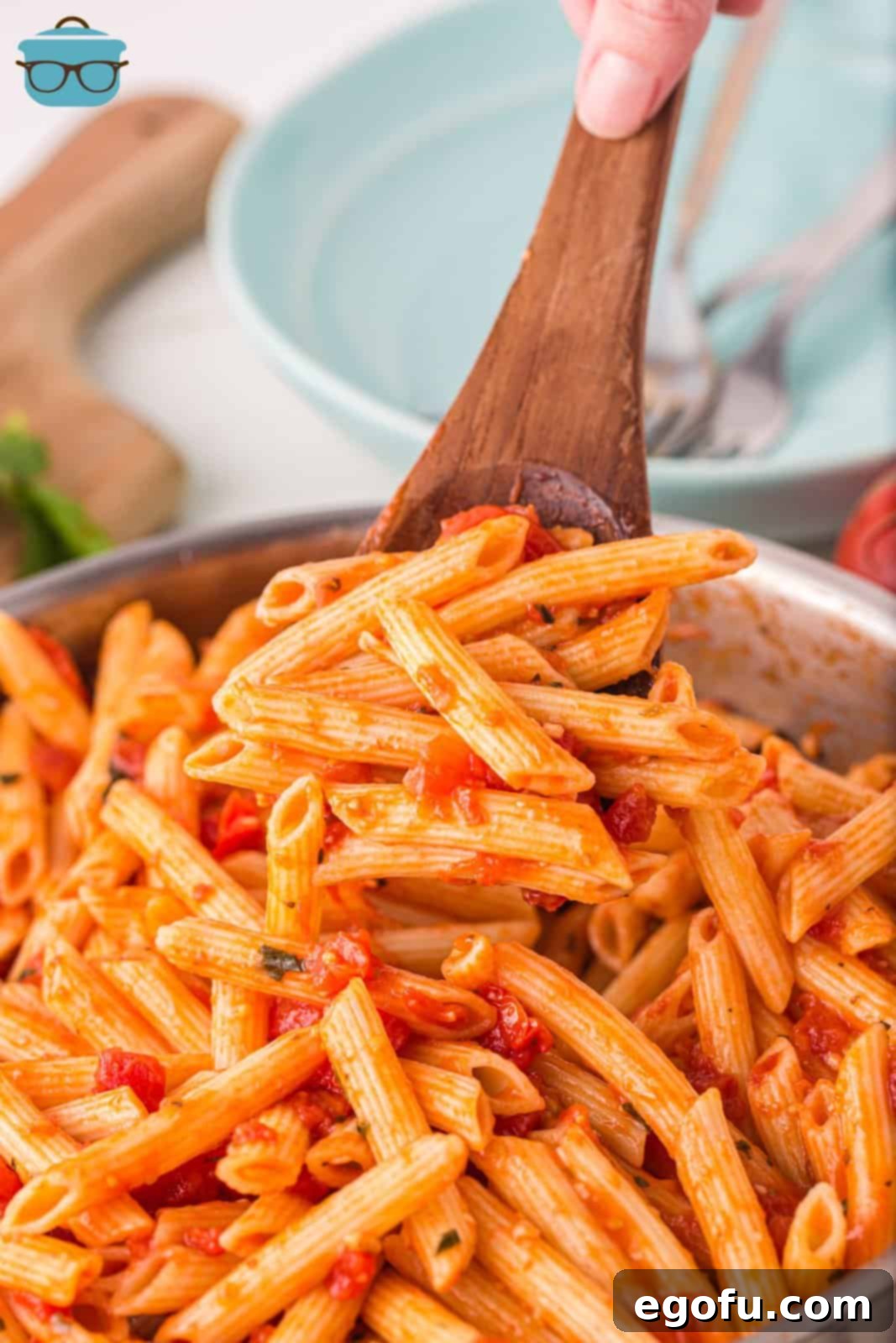 Penne with Garden Tomato Sauce 2 A wooden spoon holding a bit of penne pasta with sauce.