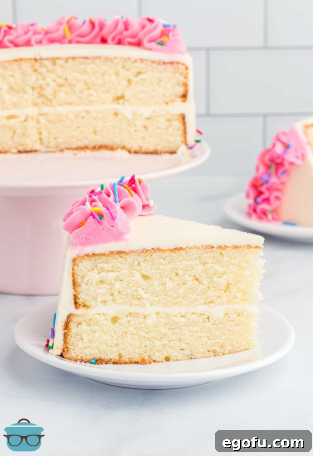 A slice of homemade white cake in front of the rest of the cake.