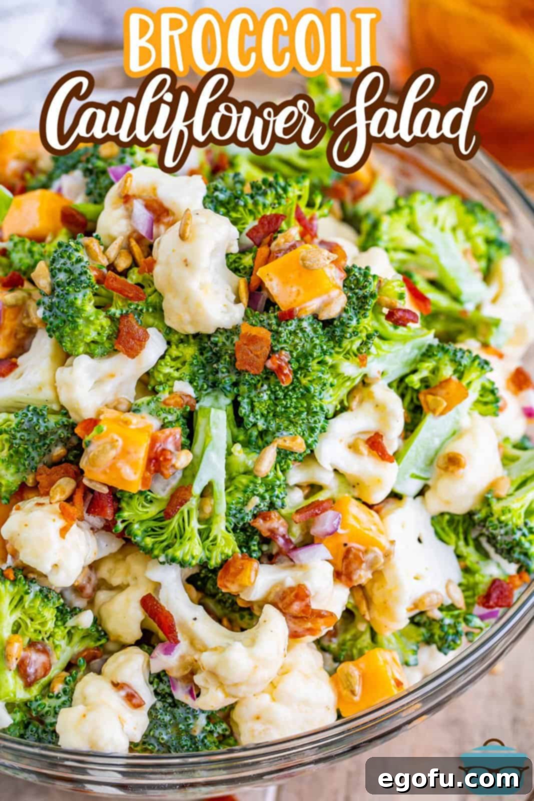 An overhead shot of a generous bowl of broccoli cauliflower salad, garnished with crumbled bacon, ready to be enjoyed.