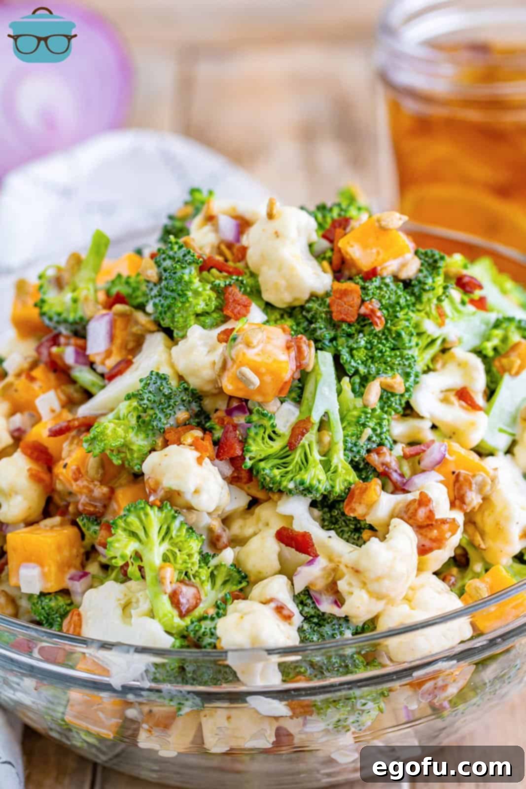 A close-up view of the tossed broccoli and cauliflower salad, showing all ingredients evenly coated in the creamy dressing.