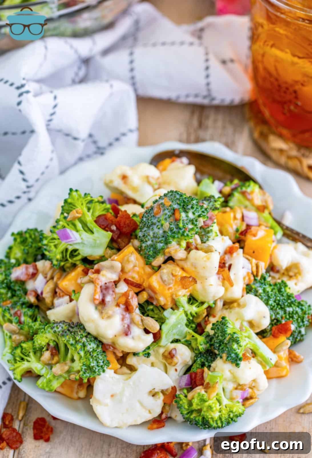 A large, inviting bowl of chilled Broccoli and Cauliflower salad, perfectly mixed and ready to be served.