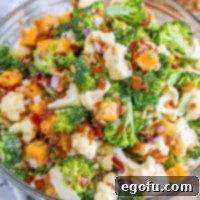 A colorful bowl of broccoli cauliflower salad.