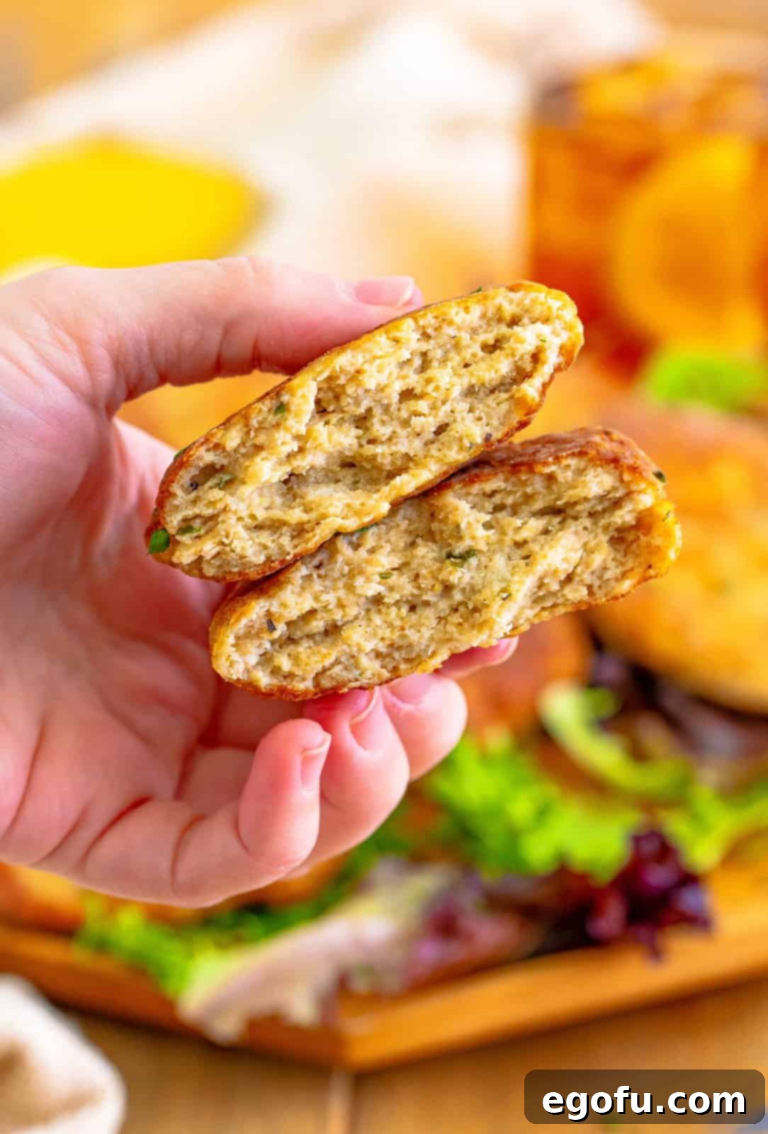 A hand holding a broken Chicken Patty.