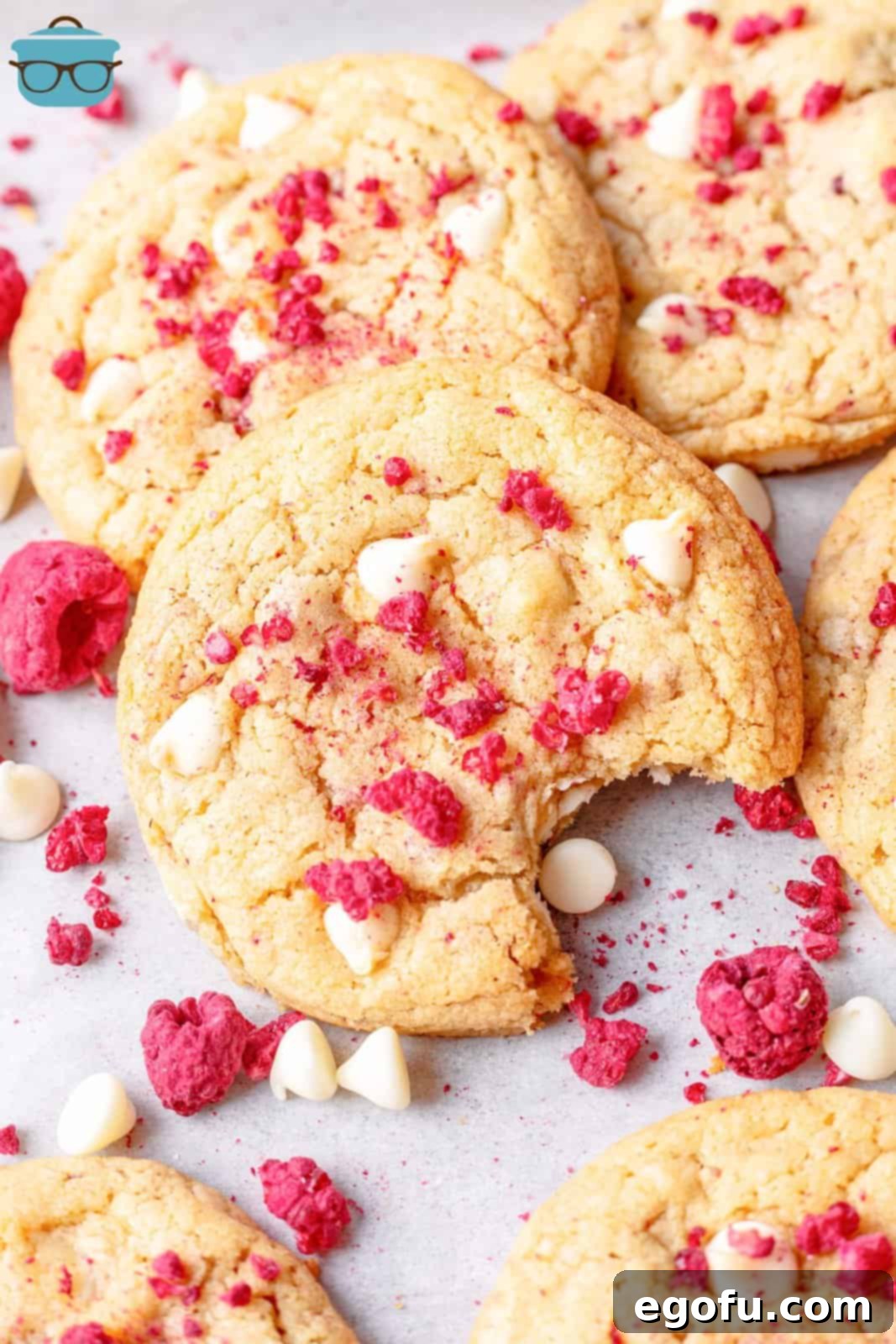 Subway Raspberry Cheesecake Bliss Bites 2 Birkaç ahududulu cheesecake kurabiyesi ve bir tanesinden ısırık alınmış, yumuşak iç kısmını gösteriyor.