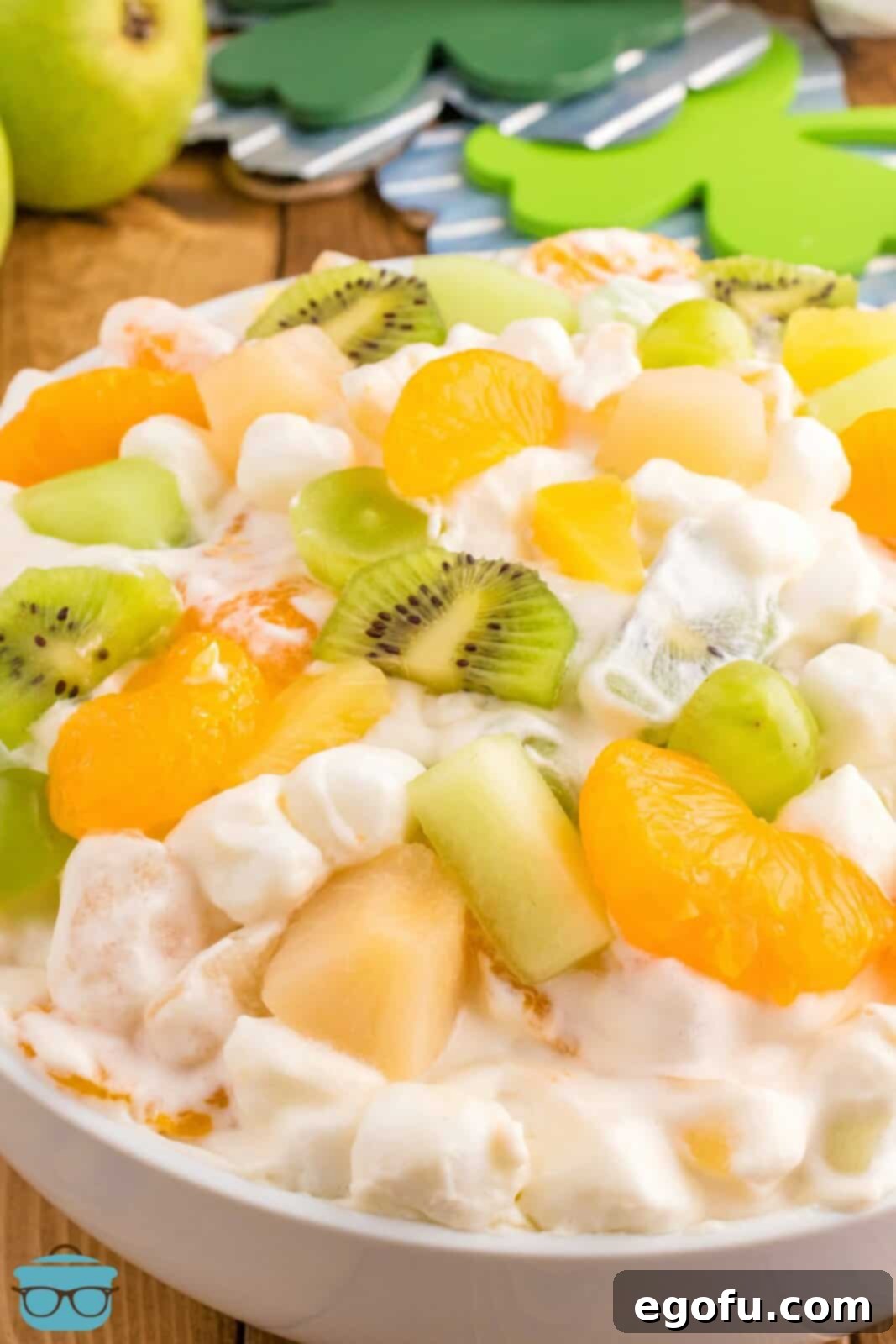 Emerald and Golden Ambrosia Delight 2 A close-up view of a vibrant gold and green St. Patrick's Day Ambrosia Salad, showcasing its creamy texture and fresh fruit.