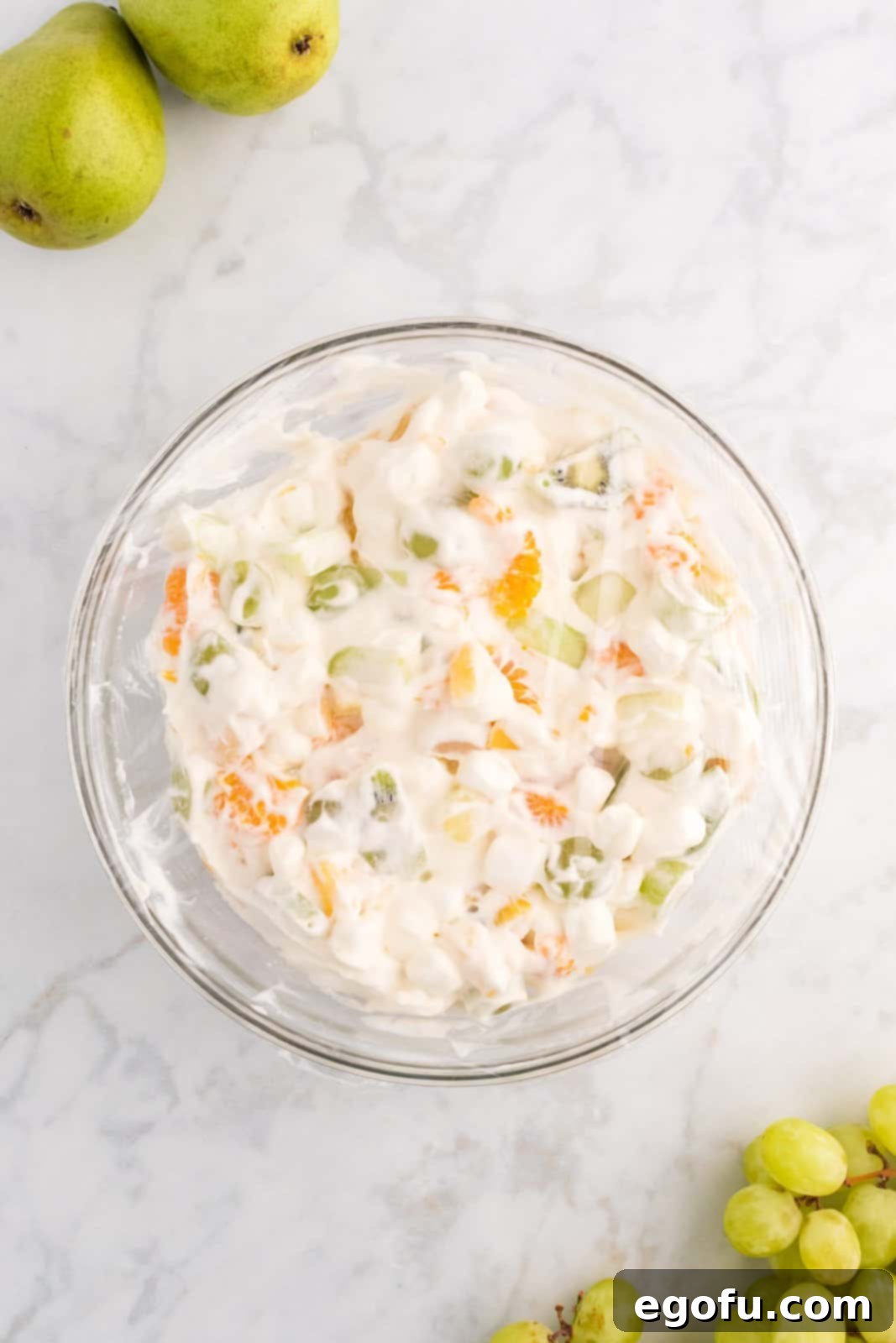 Emerald and Golden Ambrosia Delight 8 The homemade whipped cream gently mixed with the green and gold fruits and marshmallows, creating a creamy and colorful ambrosia salad.