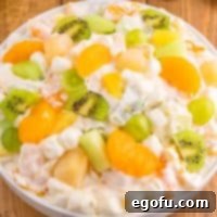 Emerald and Golden Ambrosia Delight 10 A bowl of ambrosia salad with green and orange or gold ingredients, a vibrant and festive dish.