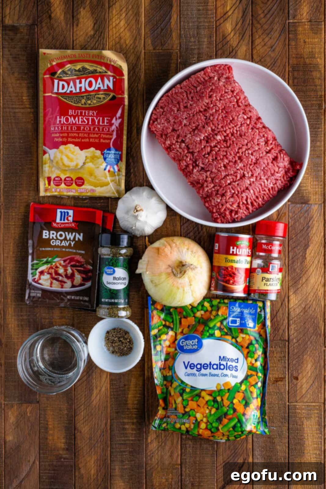 Comforting Slow Cooker Shepherd's Pie 4 Ground beef, instant potatoes, frozen vegetables, gravy mix, onion, garlic cloves, water, tomato paste, parsley, Italian seasoning, and black pepper.