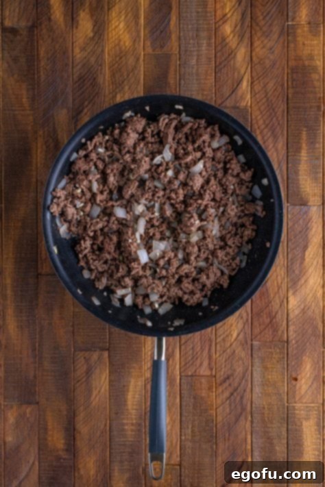 Comforting Slow Cooker Shepherd's Pie 11 A skillet with cooked ground beef and onion.
