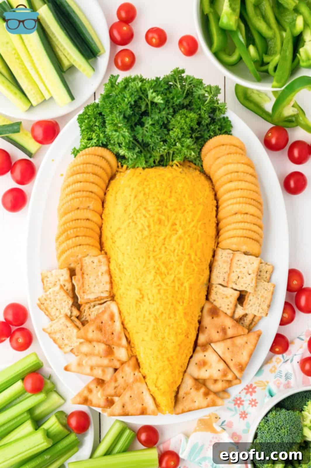 Bunny's Garden Cheeseball 2 A charming Easter Carrot Cheeseball elegantly presented on a platter, surrounded by an array of crackers and gourmet cheeses, ready for serving.