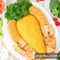 Bunny's Garden Cheeseball 10 An Easter Carrot Cheeseball proudly displayed on a platter, surrounded by an appetizing selection of crackers and other dippable treats.