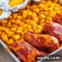 One-Pan BBQ Chicken Dinner 12 Looking closer at a sheet pan with cooked BBQ chicken, potatoes, and corn.