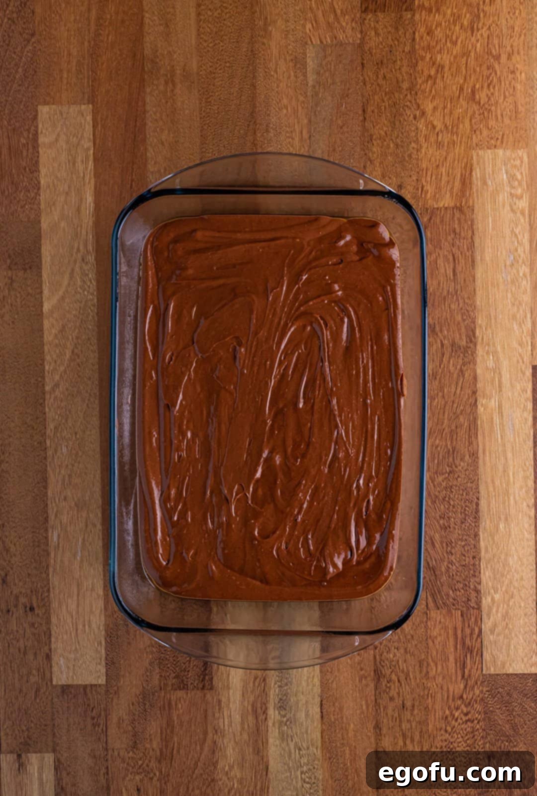Dr Pepper Cake batter neatly poured into a 9x13 inch baking dish, ready for the oven.