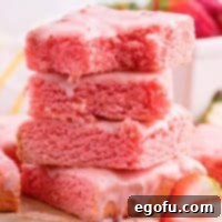 Strawberry Swirl Brownie Bliss 10 A couple of glazed Strawberry Brownies with a few bites missing, piled invitingly.