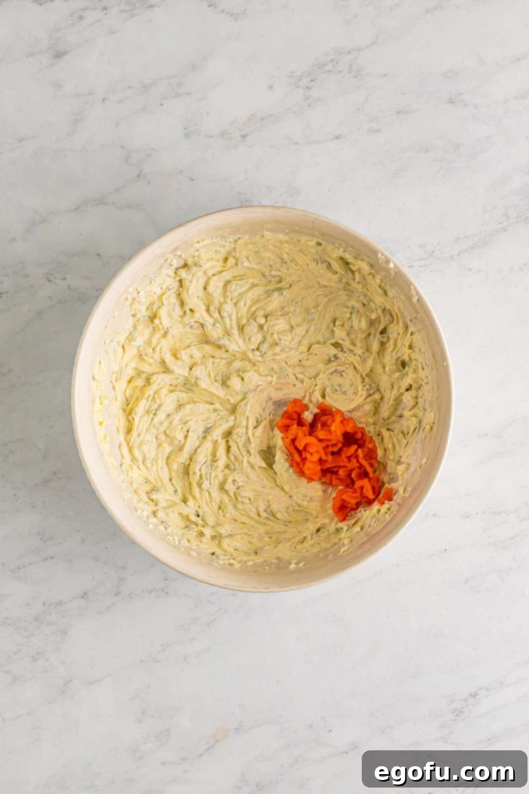 A beautifully prepared dip, with tender flakes of smoked salmon gently folded into the creamy, herb-flecked base, showcasing the rich texture before chilling and serving.