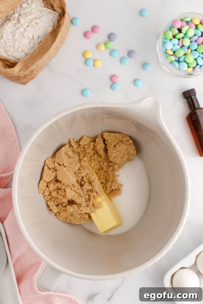 A mixing bowl with butter, light brown sugar and granulated sugar.